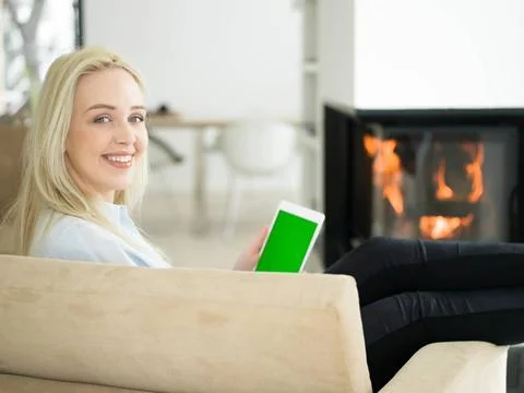 Young woman using tablet computer in front of fireplace beautiful young wo... Stock Photos