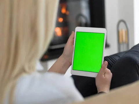 Young woman using tablet computer in front of fireplace beautiful young wo... Stock Photos