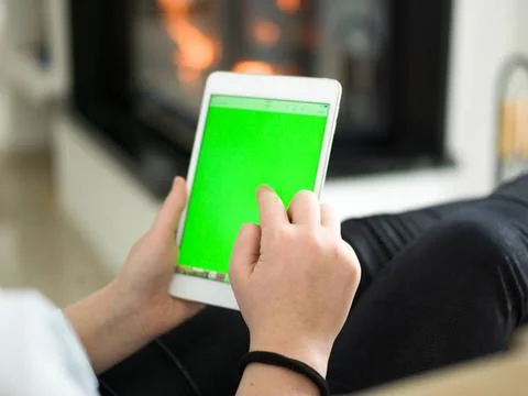 Young woman using tablet computer in front of fireplace beautiful young wo... Stock Photos