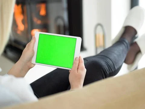 Young woman using tablet computer in front of fireplace beautiful young wo... Stock Photos