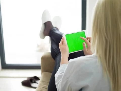 Young woman using tablet computer in front of fireplace beautiful young wo... Stock Photos