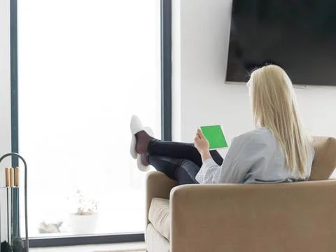 Young woman using tablet computer in front of fireplace beautiful young wo... Stock Photos