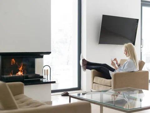 Young woman using tablet computer in front of fireplace beautiful young wo... Stock Photos