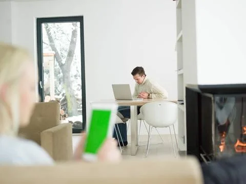 Young woman using tablet computer in front of fireplace beautiful young wo... Stock Photos
