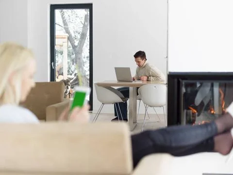 Young woman using tablet computer in front of fireplace beautiful young wo... Stock Photos