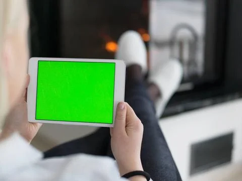 Young woman using tablet computer in front of fireplace beautiful young wo... Stock Photos