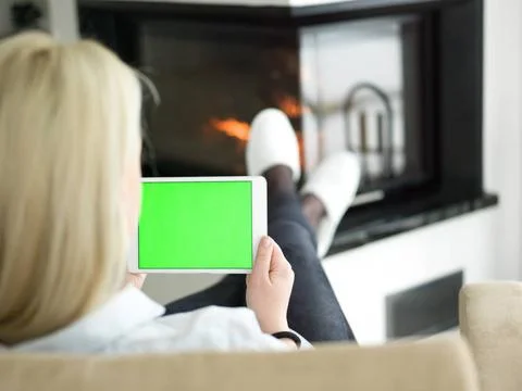 Young woman using tablet computer in front of fireplace beautiful young wo... Stock Photos