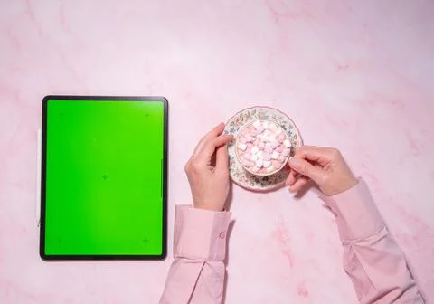 Young woman using tablet device with green screen and drinking hot cappuccino Stock Photos