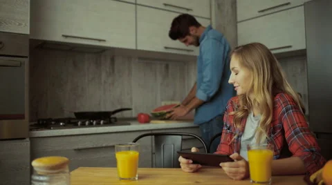 Young woman using tablet, man cutting watermelon Stock Footage 68728846