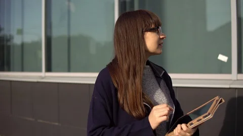 Young woman is using tablet next to an office building. Stock Footage 116195358