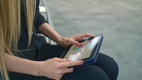 Young woman using tablet on office patio bench during daytime Stock Footage 340270701