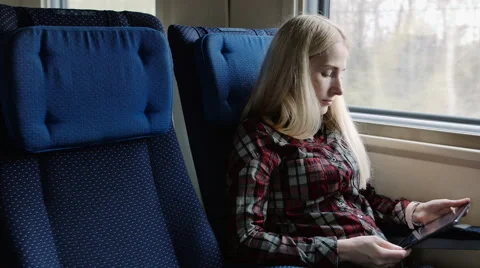 Young woman using tablet while traveling by train Stock Footage 62654102