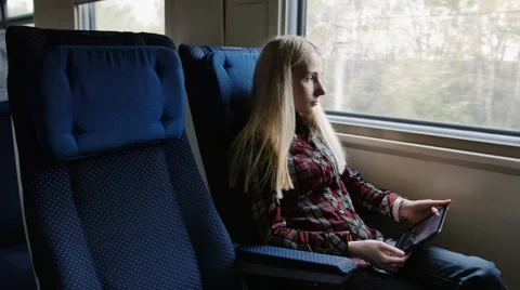 Young woman using tablet while traveling by train 스톡 동영상 62654365