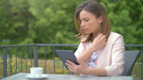 Young woman using a tablet while drinking tea Stock Footage 64543958
