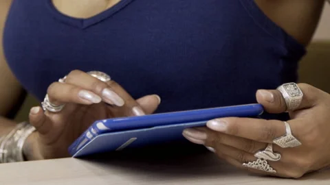 Young woman is using tablet while sitting at table in cafe. Stock Footage 85584397