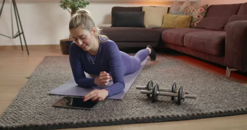 Young woman using tablet while getting ready for workout at home. Stock Footage 171019514