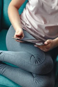 Young woman using tablet while sitting in a comfortable chair Stock Photos