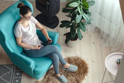 Young woman using tablet while sitting in a comfortable chair Stock Photos