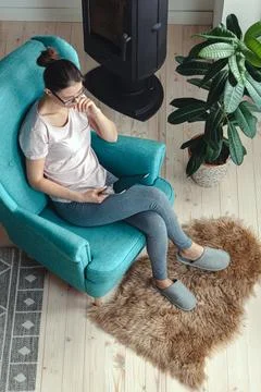 Young woman using tablet while sitting in a comfortable chair 스톡 사진