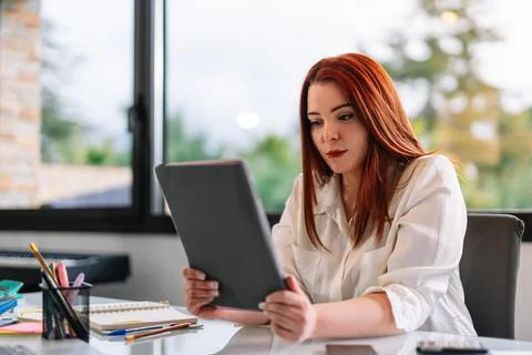Young woman using tablet at work in home Stock Photos