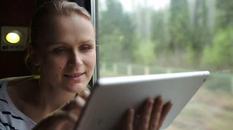 Young woman using touch pad sitting by the window in the train 스톡 동영상 39793831