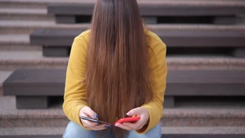 Young woman, using two smartphone modern tech on big city urban street outside. Stock Footage 249947837