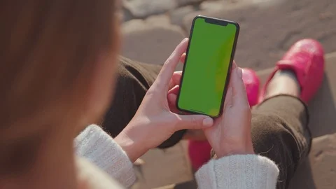 Young woman using vertical mock-up smartphone relaxing in the street. Close-up Video stock 118155576