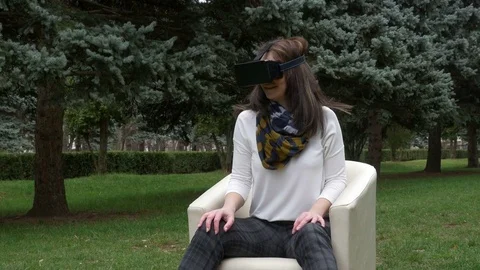 Young woman using virtual reality glasses in park looking around and dry le.. Stock Footage 71467985