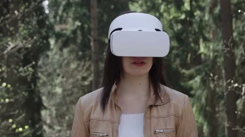Young woman using virtual reality glasses in forest Stock Footage 74760665