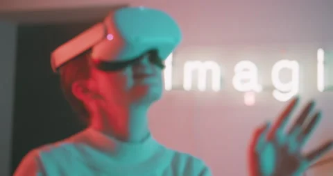 Young woman using virtual reality glasses with neon lights on the background Stock Footage 201114552