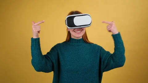 Young woman using VR app headset helmet. Isolated on yellow background in studio Stock Footage 150182064