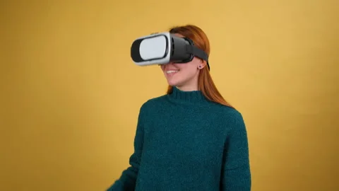 Young woman using VR app headset helmet. Slide gestures. Isolated on yellow Stock Footage 150233682