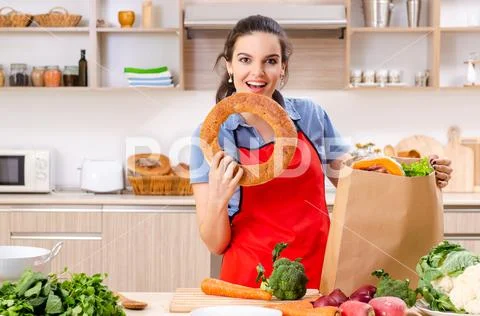 Young woman with vegetables in the kitchen Stock Photos