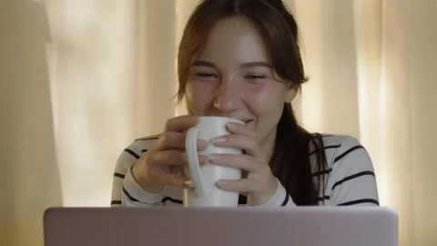 A young woman is videoconferencing while sitting at home. 動画素材 144932016