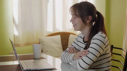 A young woman is videoconferencing while sitting at home. 動画素材 144932294