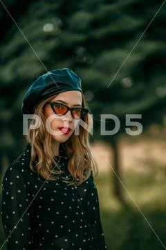 Young woman in vintage black polka dot dress posing outside Stock Photos