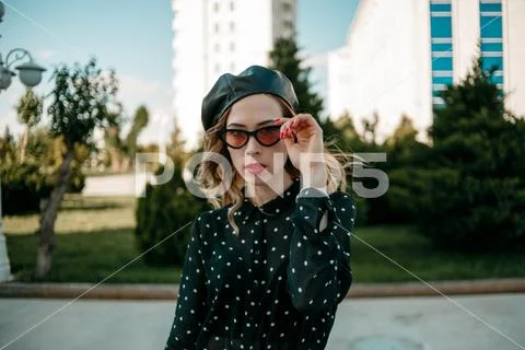 Young woman in vintage black polka dot dress posing outside Stock Photos