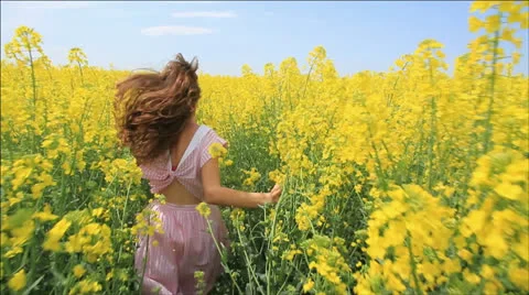 Young Woman in Vintage Dress Running through Yellow Field Touching Flowers HD Stock Footage