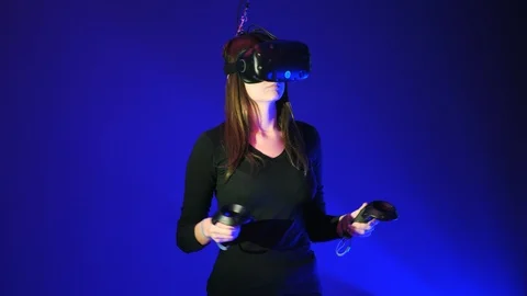 Young woman in VR headset using gamepad, remote controller have fun and play Video stock 98567699