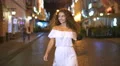 The young woman walk on the evening street. Slow motion. Wide angle 4k or 4k+ Resolution