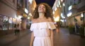The young woman walk on the evening street. Real time. Wide angle 4k or 4k+ Resolution
