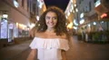The young woman walk on the evening street. Real time. Wide angle 4k or 4k+ Resolution