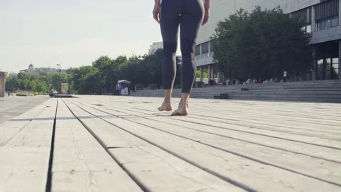 A young woman walking barefoot on wooden flooring Stock Footage