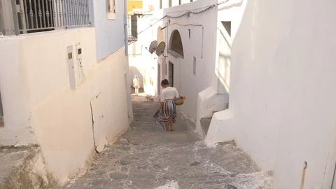 Young woman walking down steps along alley in Ponza town island, Italy. Fashion Vídeos de archivo 119876802