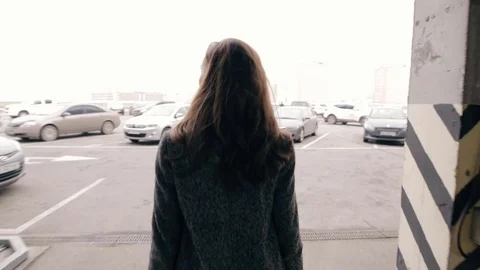 Young woman walking in a parking - back view Stock Footage