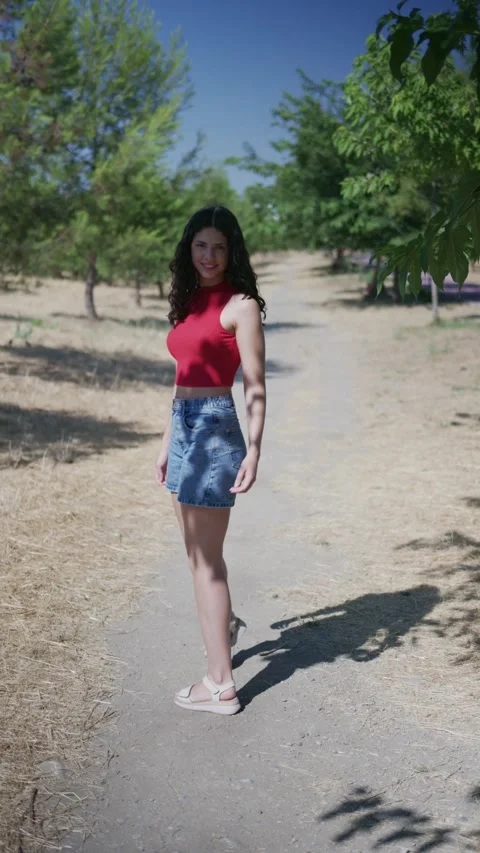 Young woman walking on path and looking back Stock Footage 339065714