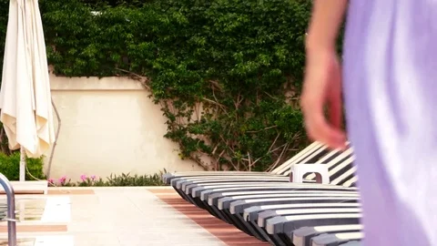 Young woman walking by the simming pool Stock Footage 75040341