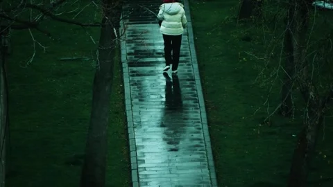 Young woman walking through the park in rainy weather Stock Footage 306310853