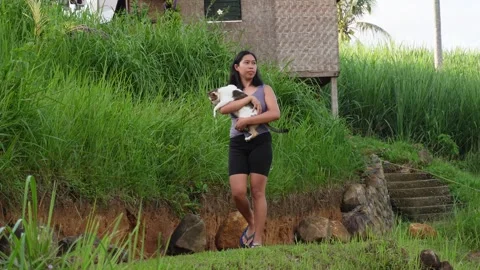 A young woman walking while carrying a cat. Stock Footage 320335148