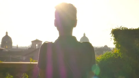Young woman walks on balcony in rome to see cityscape Stock Footage